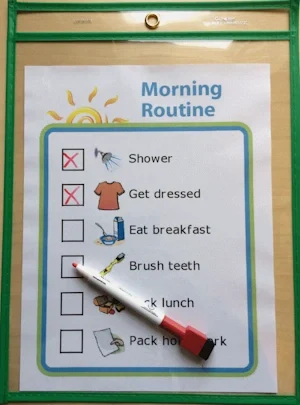Morning routine picture checklist in a plastic sleeve with dry erase marker